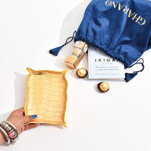 Golden Platter shaped like Alladin's Magic Carpet with a Ferrero Rocher and a book