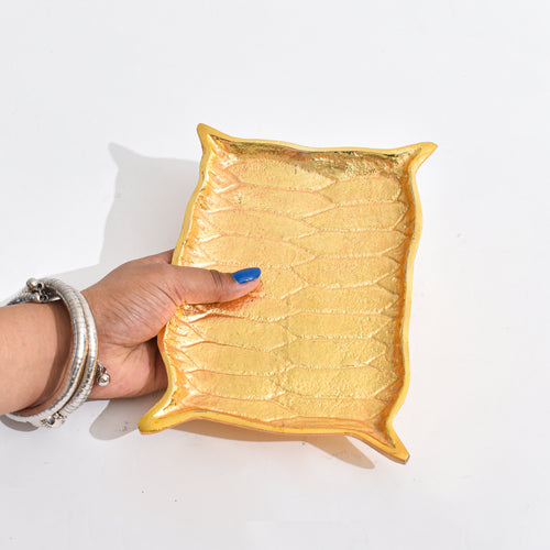 Golden Platter shaped like Alladin's Magic Carpet with a Ferrero Rocher and a book