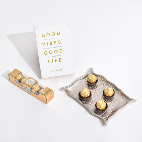 Silver Platter shaped like Alladin's Magic Carpet with a Ferrero Rocher and a book