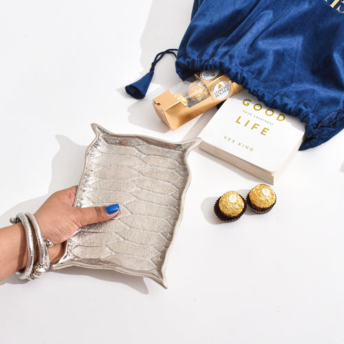 Silver Platter shaped like Alladin's Magic Carpet with a Ferrero Rocher and a book